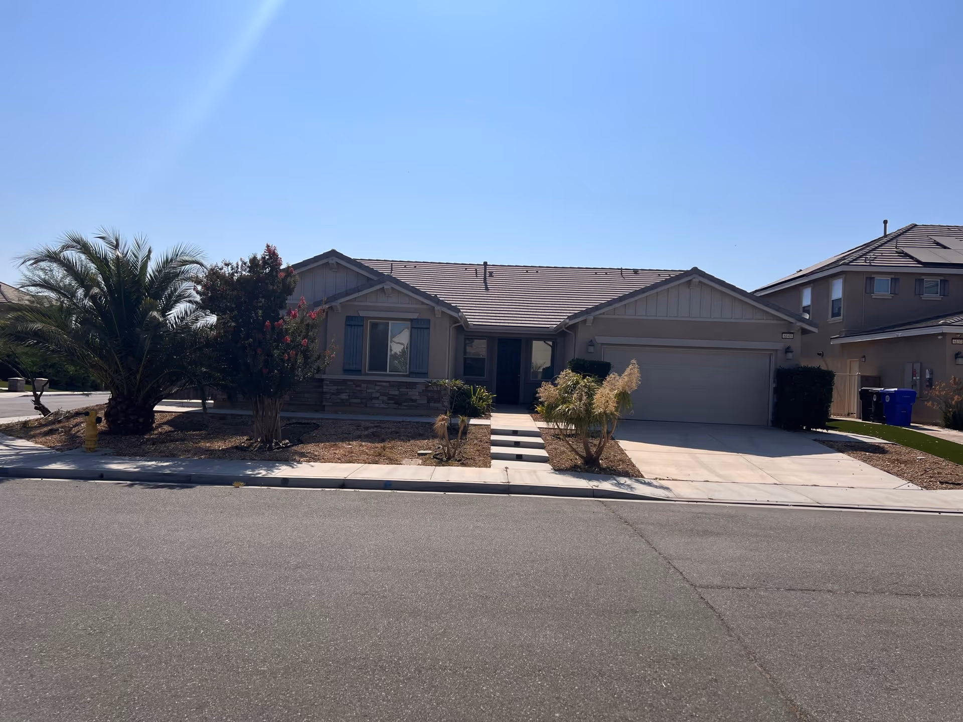 Front exterior of a single-story building with a driveway and landscaped yard.