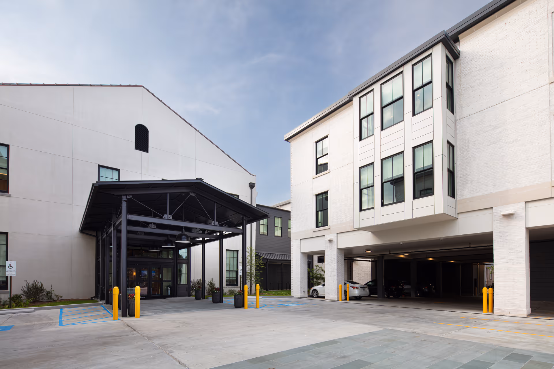 Exterior view of The Carrollton senior living facility with entrance canopy and parking.