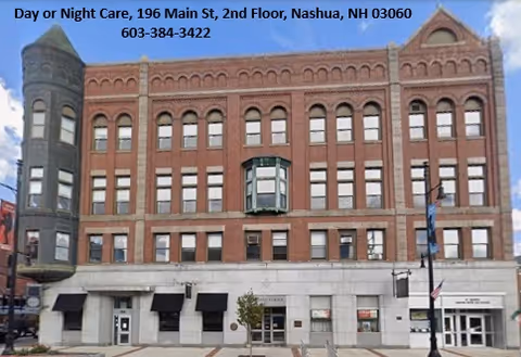Brick building facade with arched windows and ground-floor storefronts along a city street.