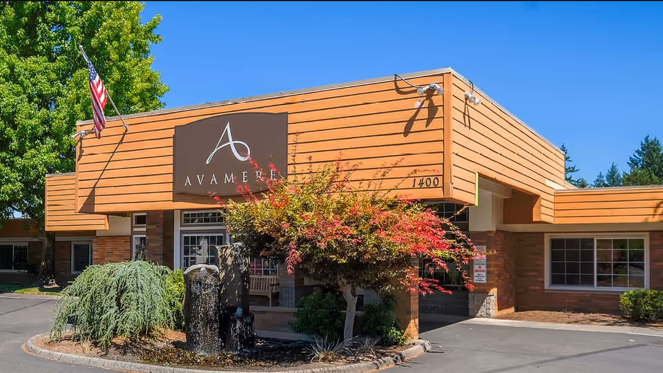 Exterior view of Avamere Rehabilitation of Oregon City building with sign, flag, and landscaping.