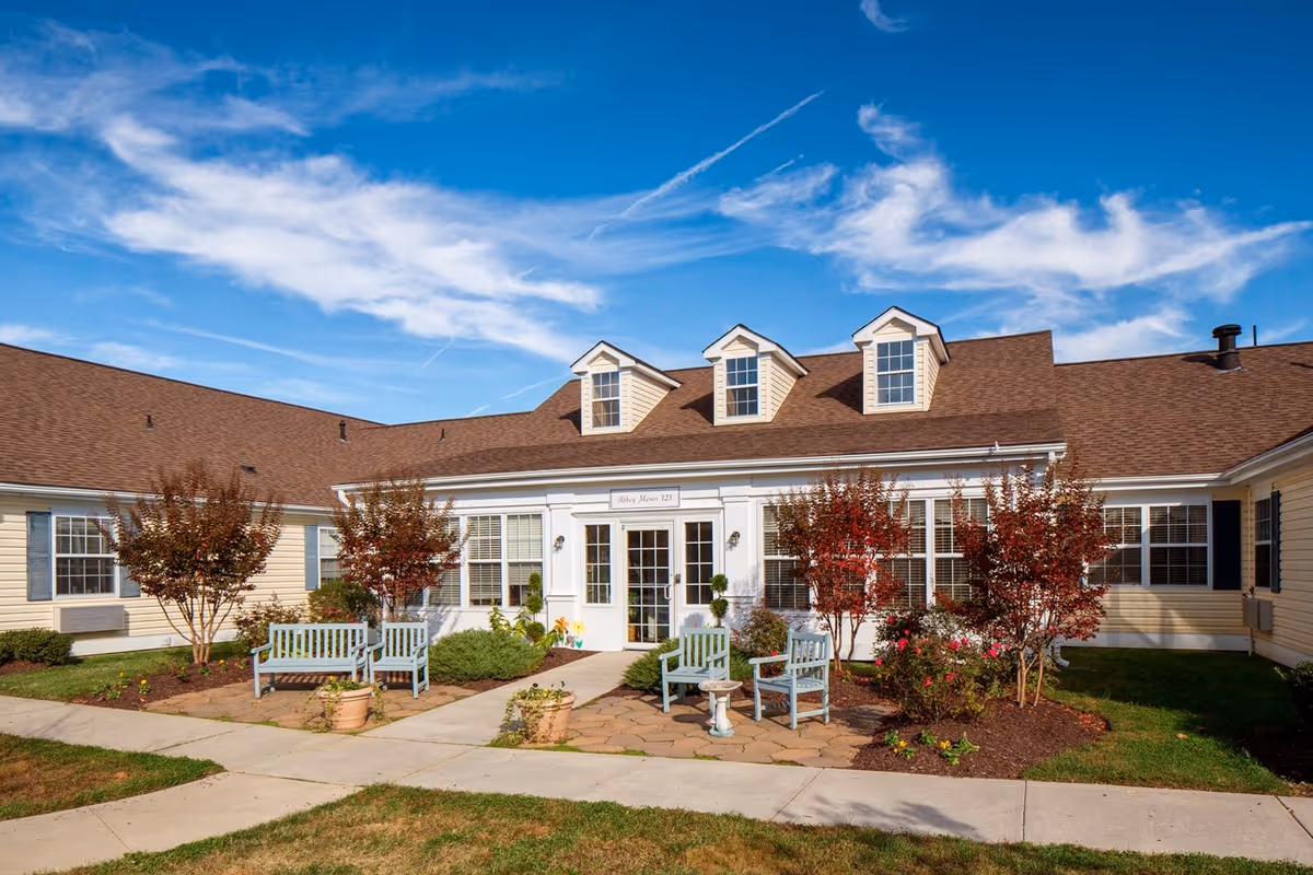 Sagepoint Gardens Assisted Living exterior entrance with benches and landscaped courtyard.