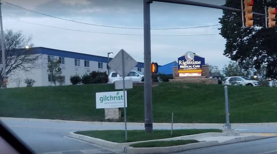 Exterior view of Gilchrist Center Baltimore with a lit RightTime Medical Care sign.