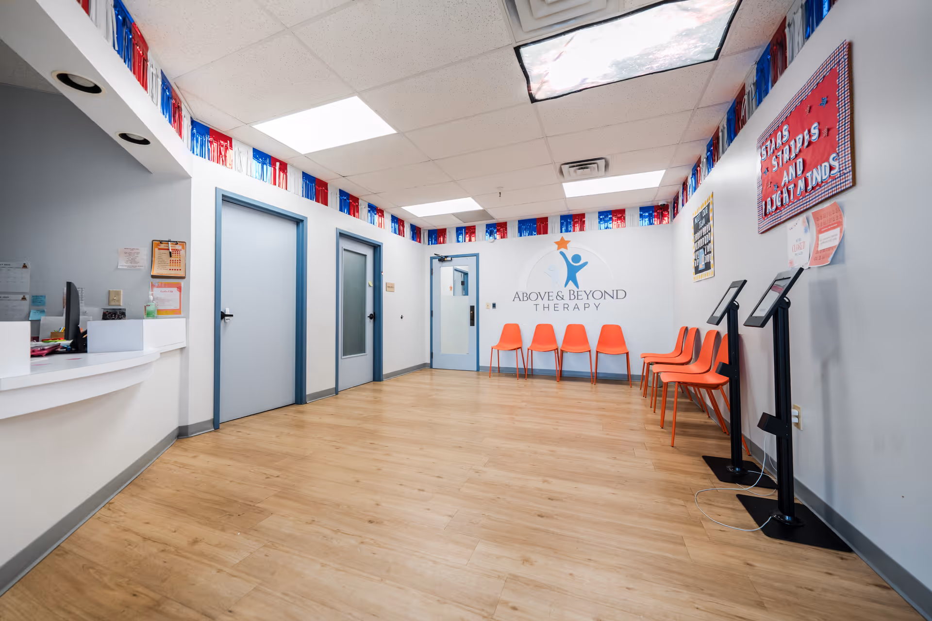 Reception area with orange chairs and a front desk at Above and Beyond Therapy Center.