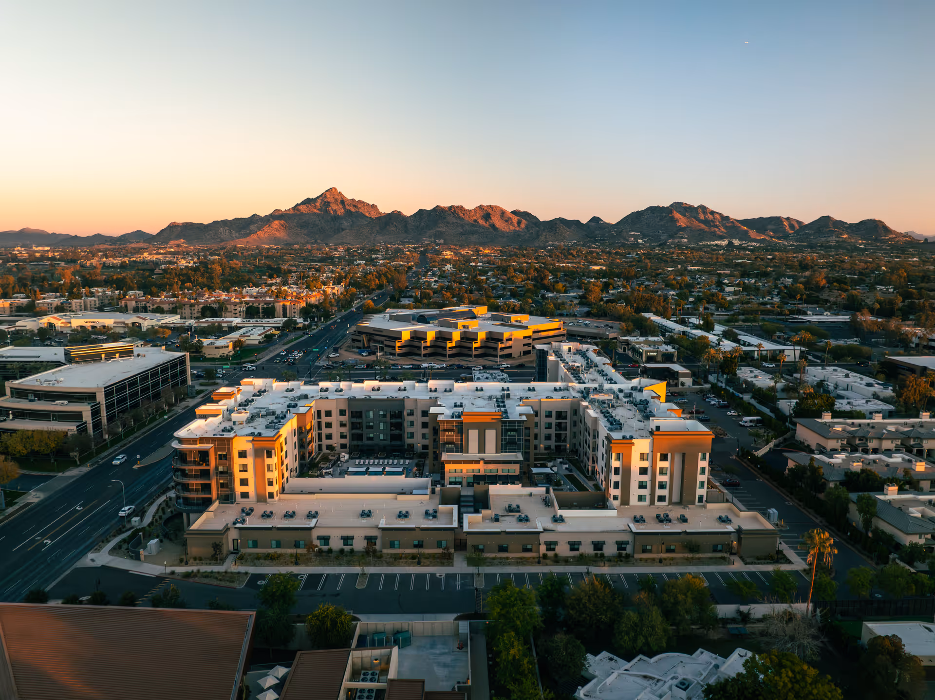 Aerial view of Clarendale Arcadia senior living campus with surrounding city and distant mountains.