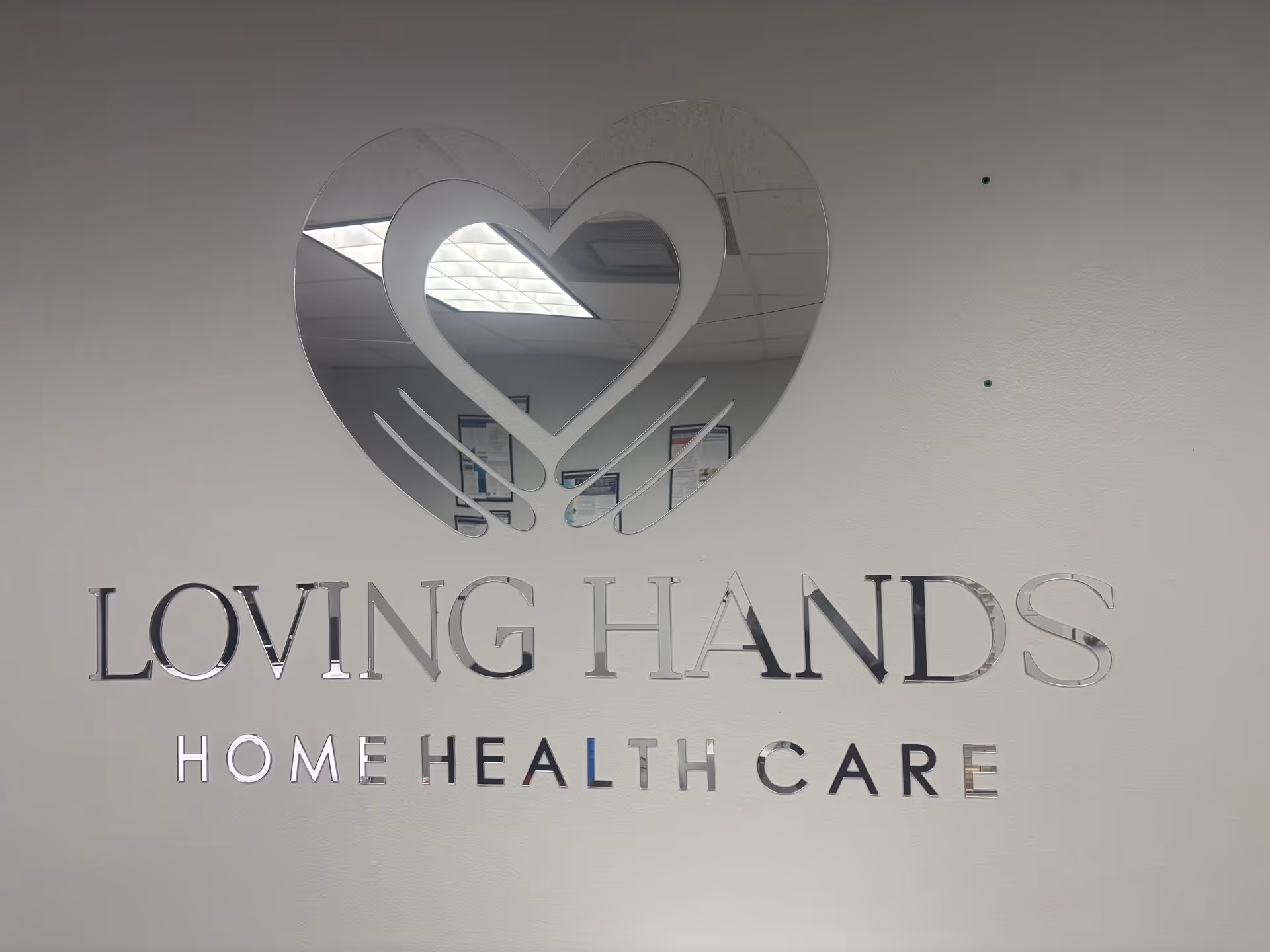 Interior wall signage displaying Loving Hands Home Health Care logo with heart design.