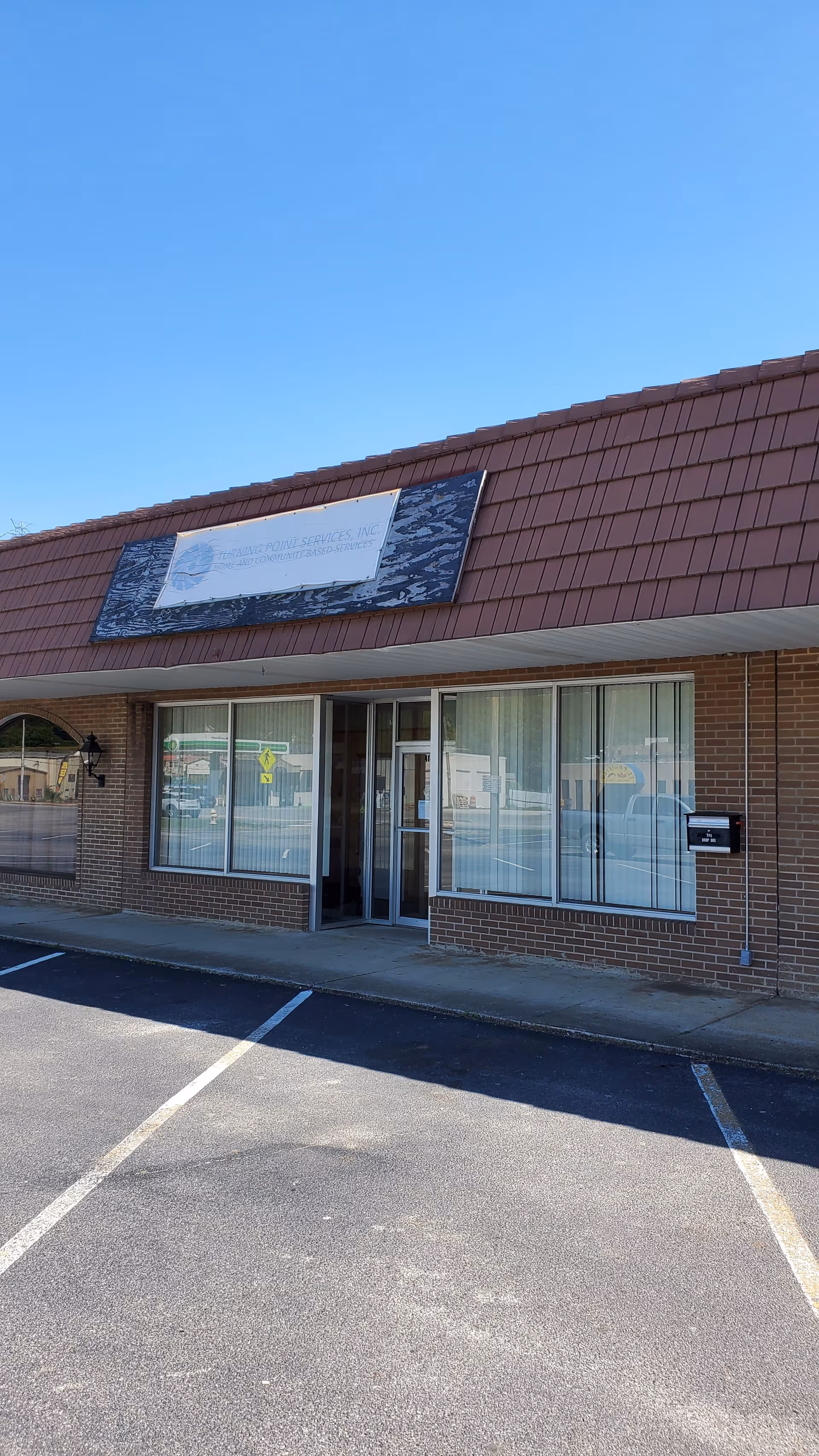 Exterior view of Turning Point Services, Inc. front entrance with brick facade and parking lot.