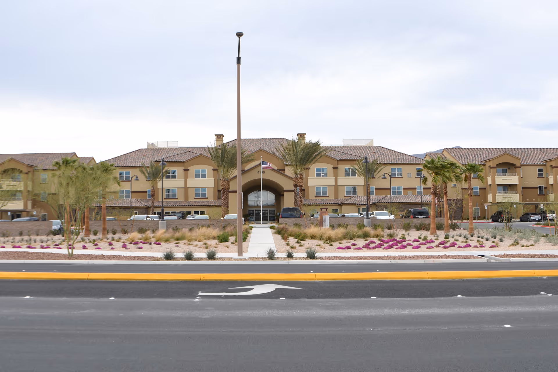 Front view of Vista Park Retirement Community building with palm trees and landscaped entrance