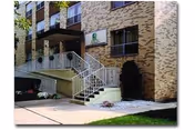 Exterior view of a brick senior living building with stairs and entrance sign.