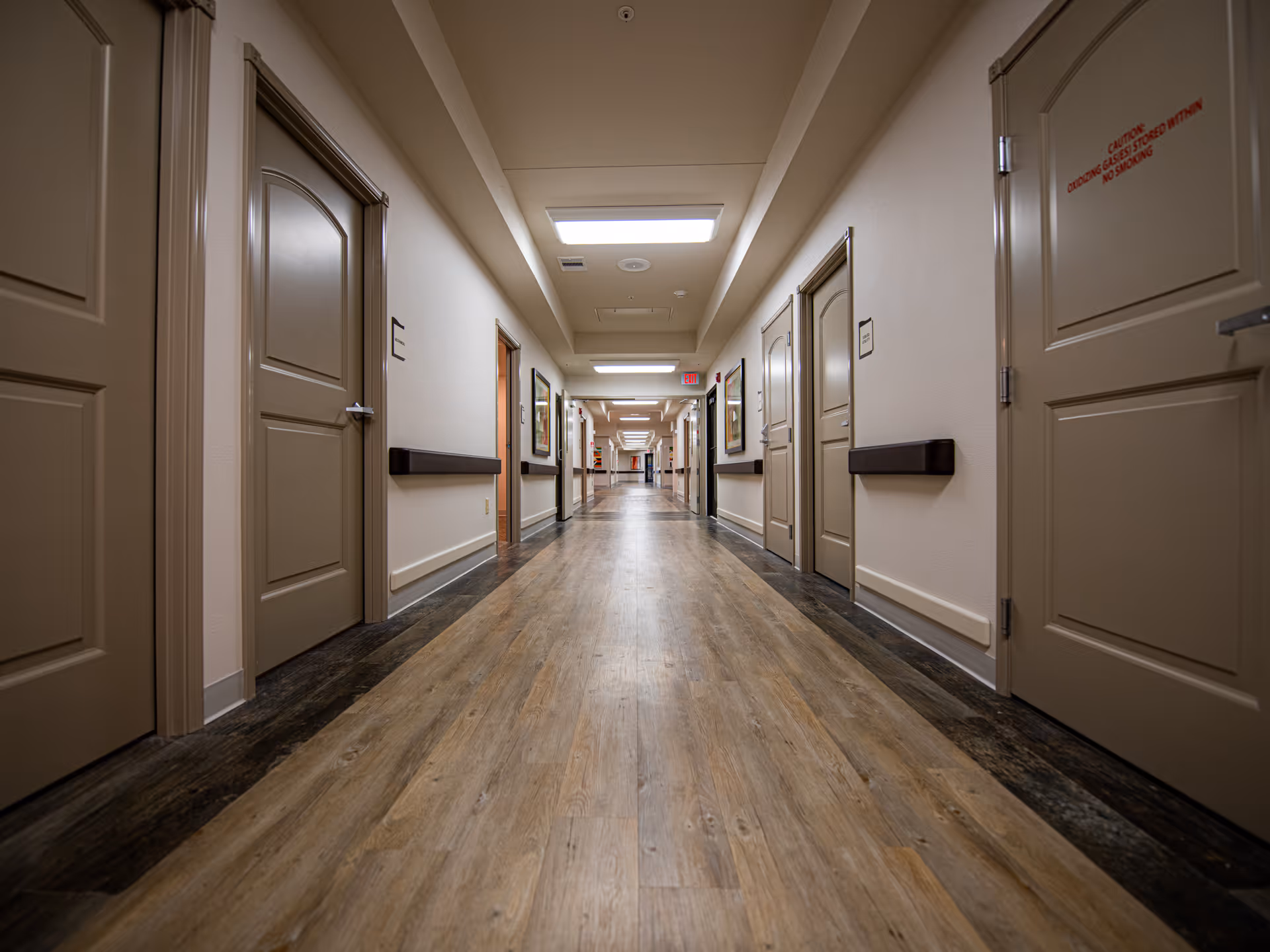 Long, well-lit hallway with closed doors along both walls.