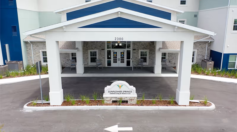Sunflower Springs at Trinity exterior entrance with a covered porte-cochere and sign.