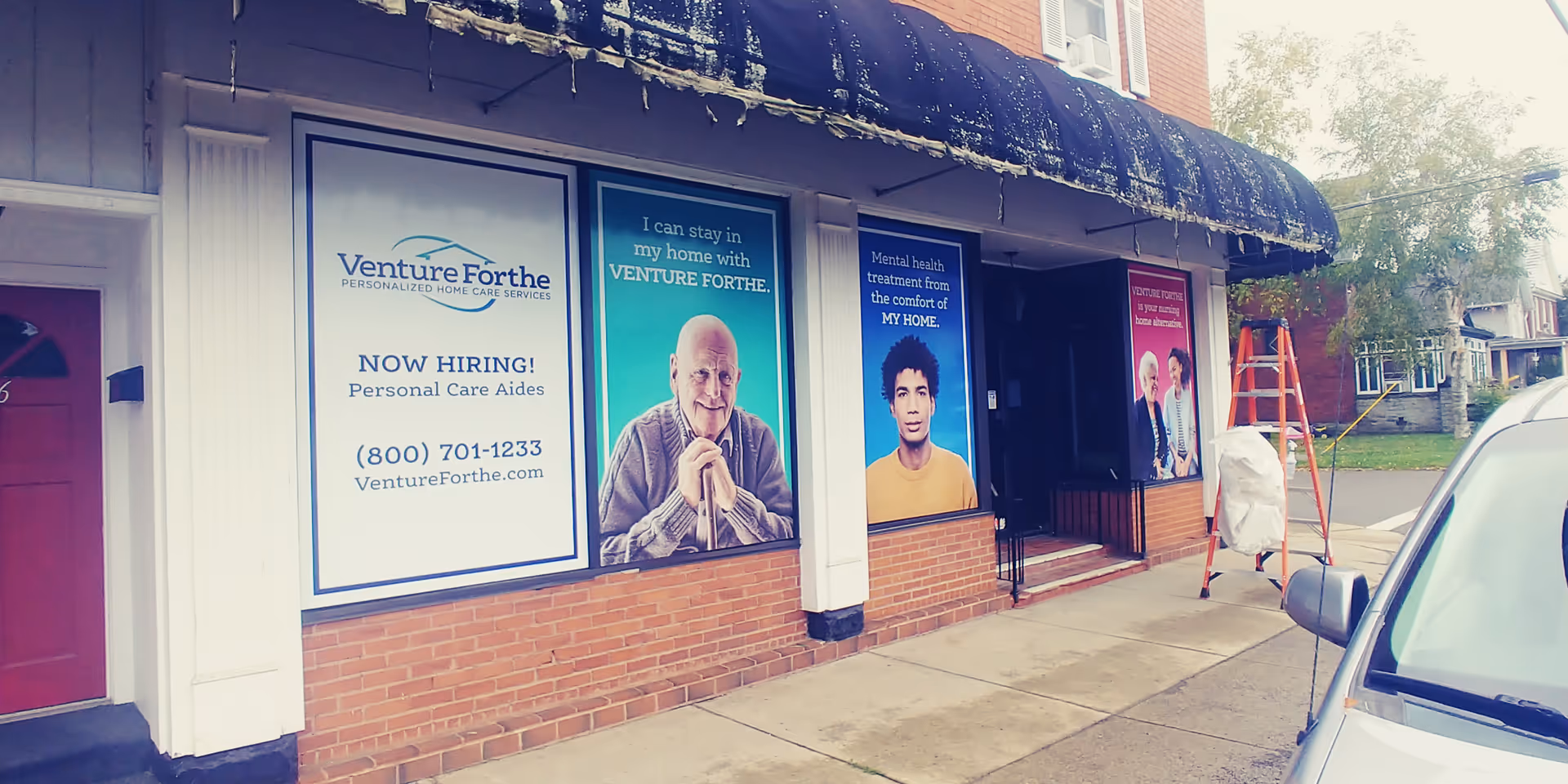 Storefront with large posters advertising Venture Forthe Hornell Training Center and hiring.