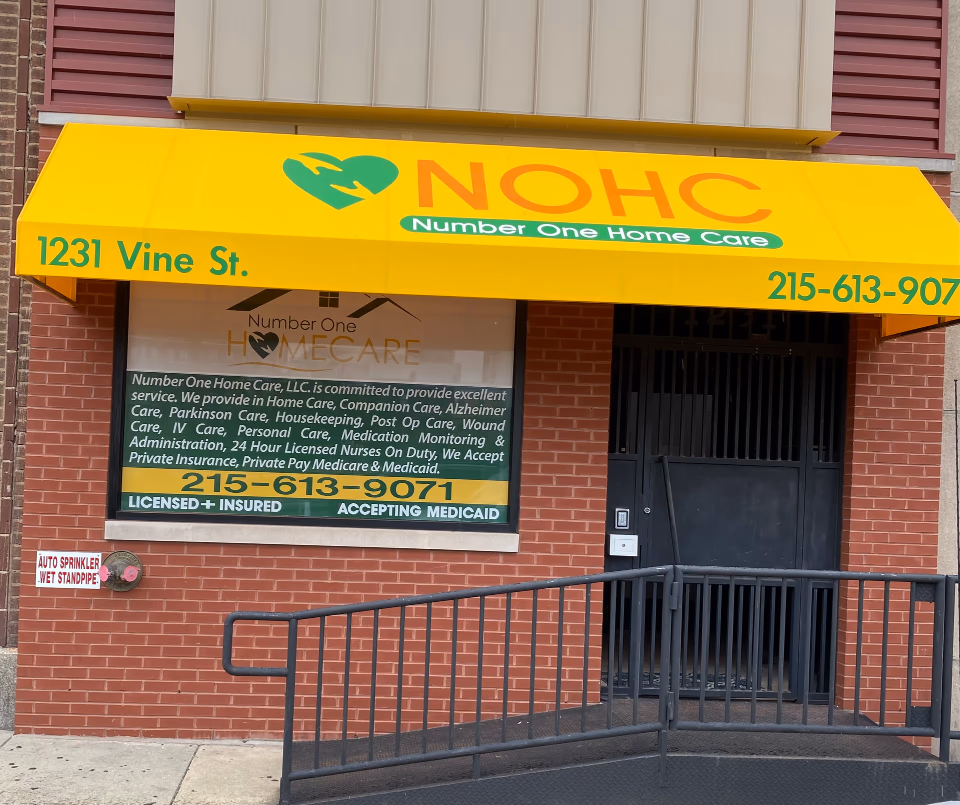Yellow awning storefront for Number One Home Care over brick exterior and ramp.