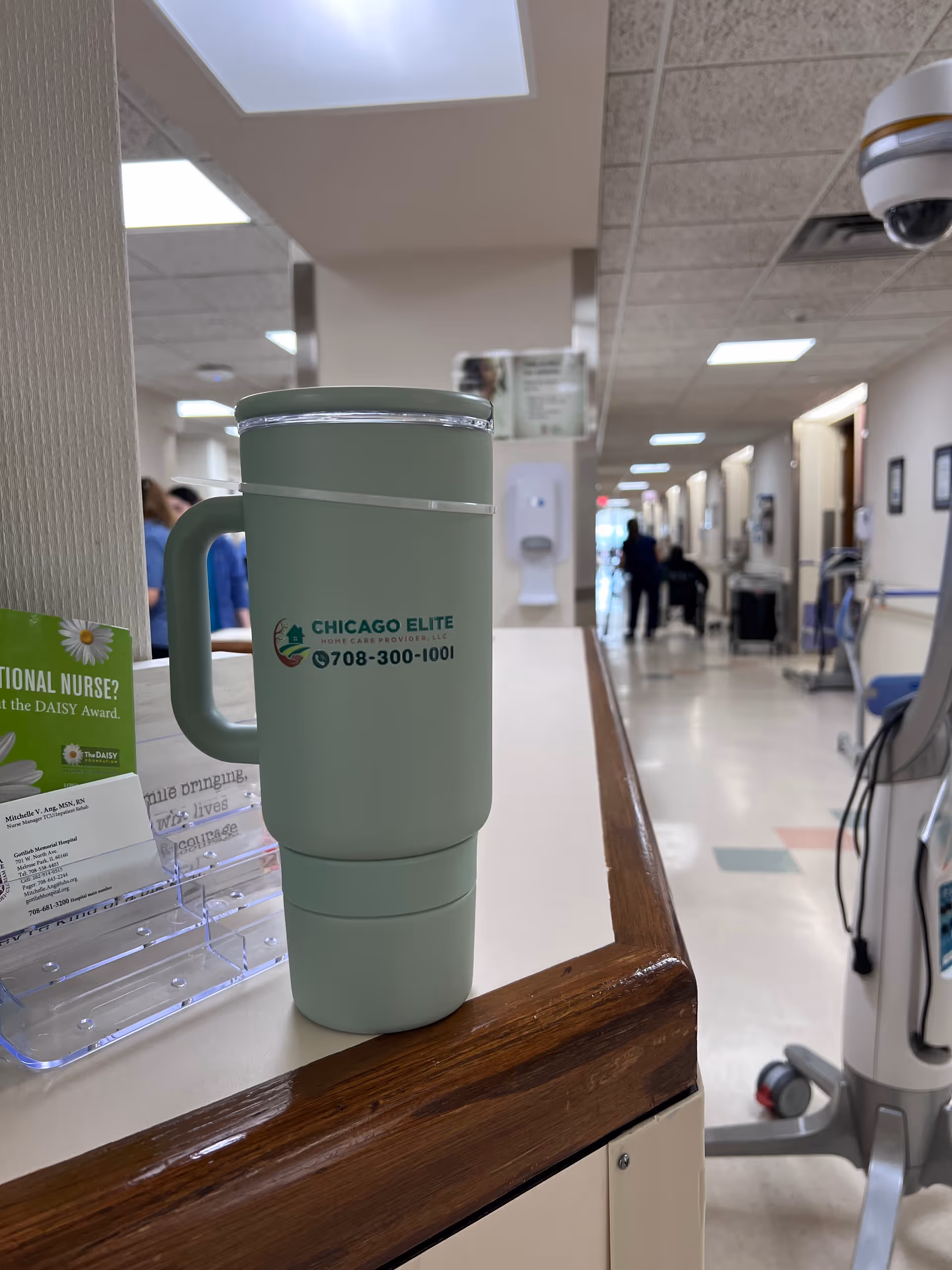Light green tumbler with logo sits on a counter in a senior care facility.