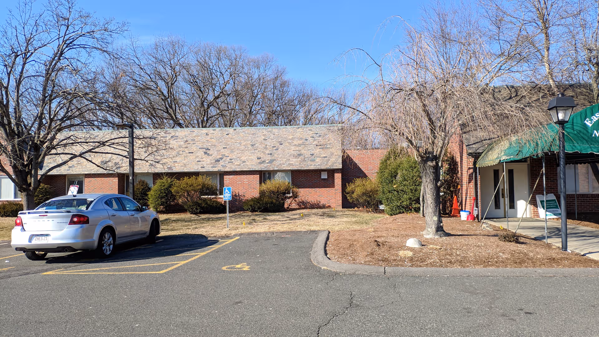 Front exterior of a brick senior care center with a parking lot and entrance canopy.