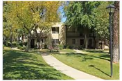 Front exterior of Heritage Park at Alta Loma with walkway, lawn, and trees.