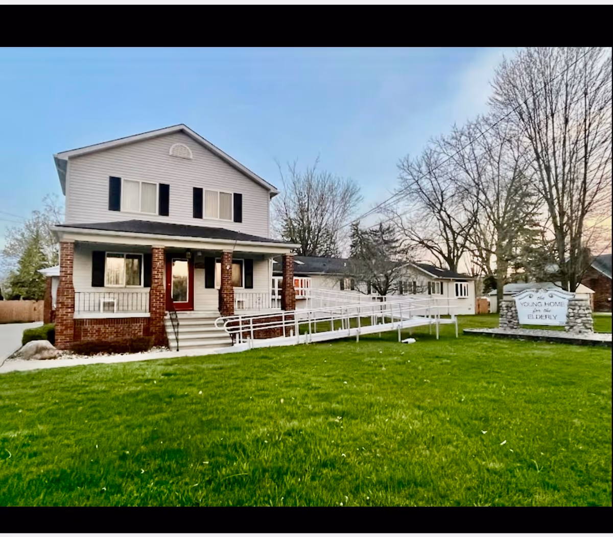 Front view of Young Home For The Elderly building with ramp and green lawn.