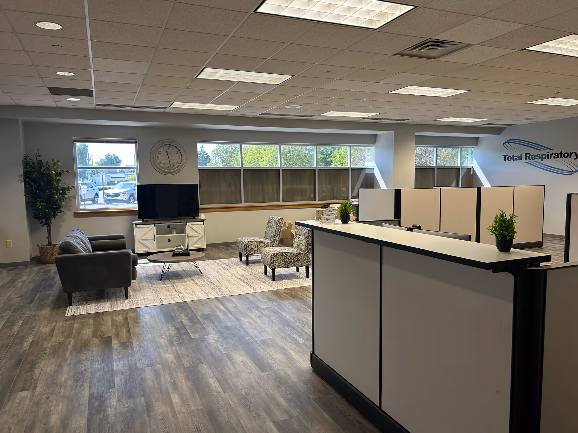 Modern reception area with a front desk, lounge seating, and large windows.