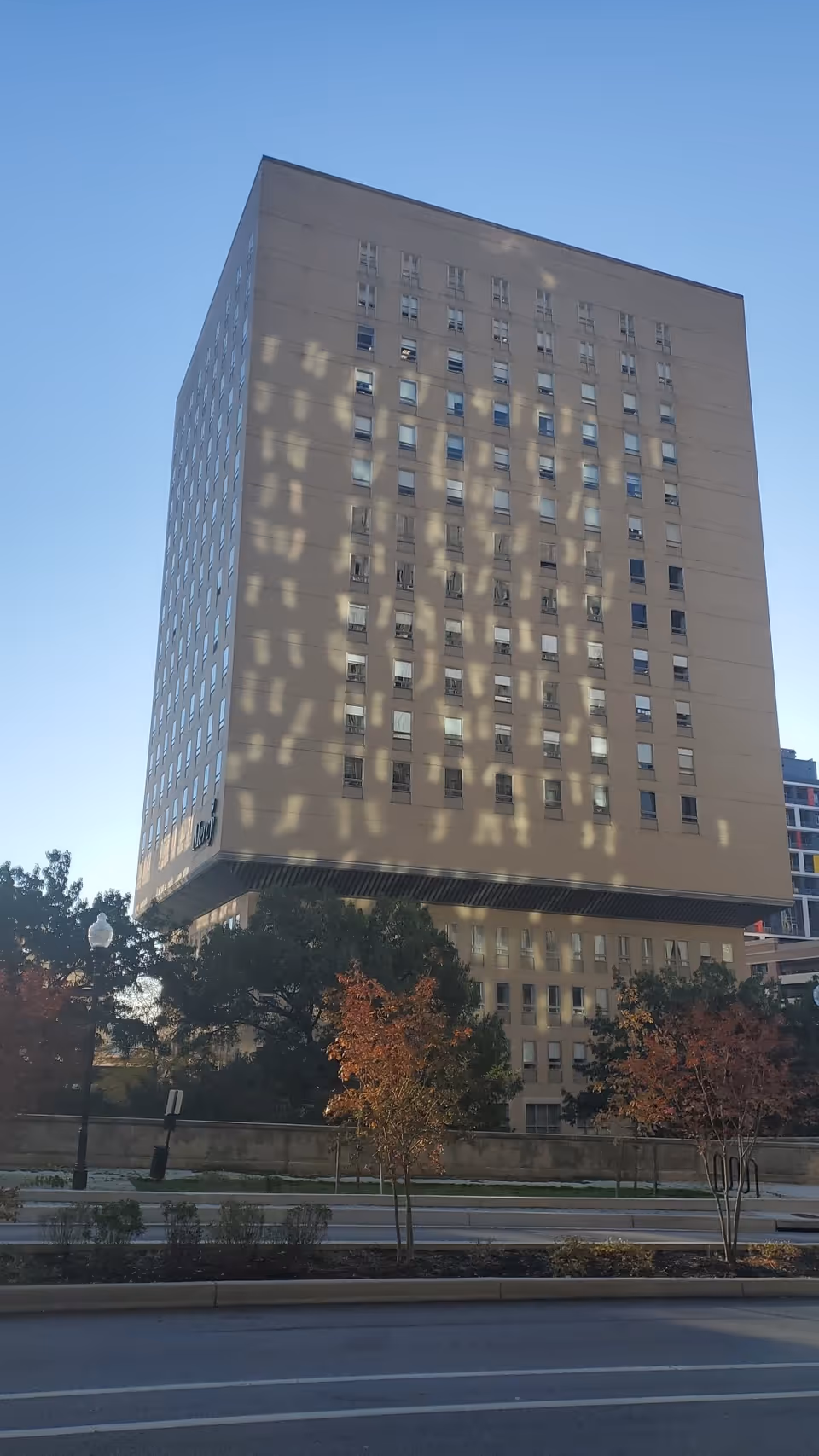 Exterior view of Mercy Medical Center's tall building with many windows and trees nearby.