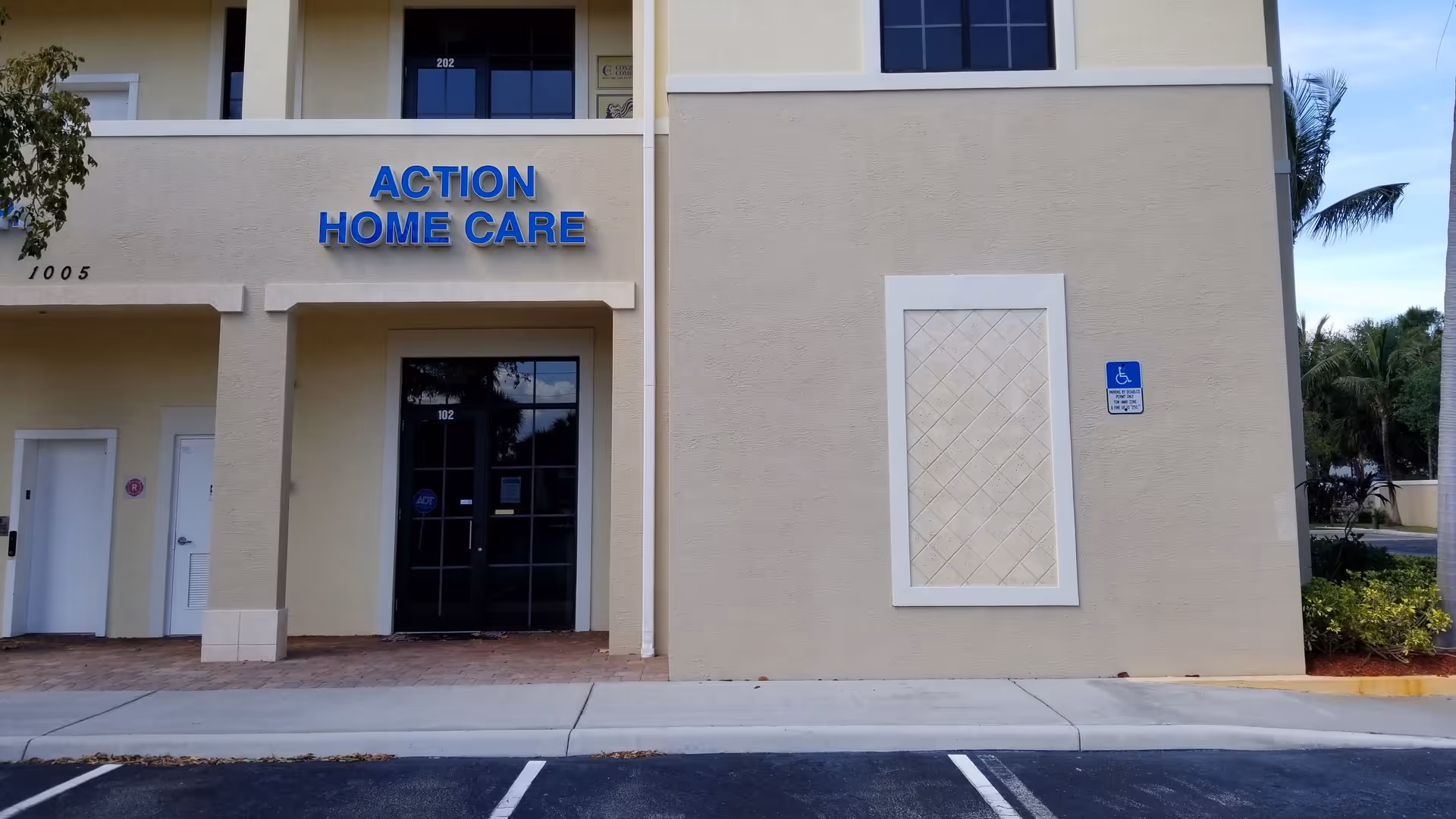 Exterior view of Action Home Care building with entrance door and handicap sign.