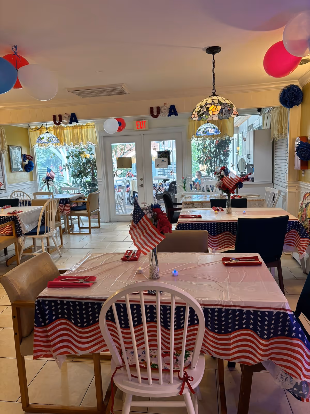 Bright dining room decorated with American flags and balloons for a celebration.