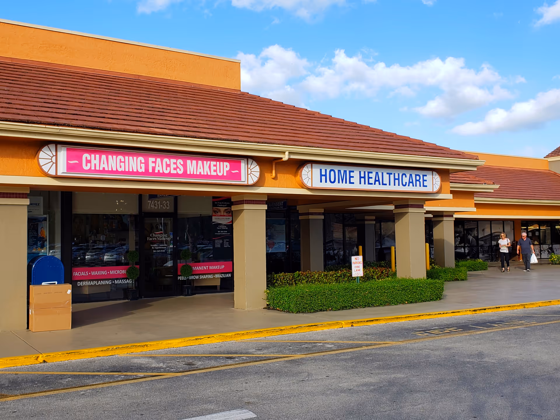Exterior view of a strip mall with makeup and home healthcare storefronts.
