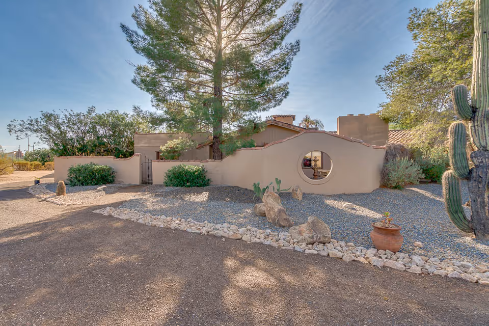 Front exterior of a desert-style senior facility with a circular window and cactus