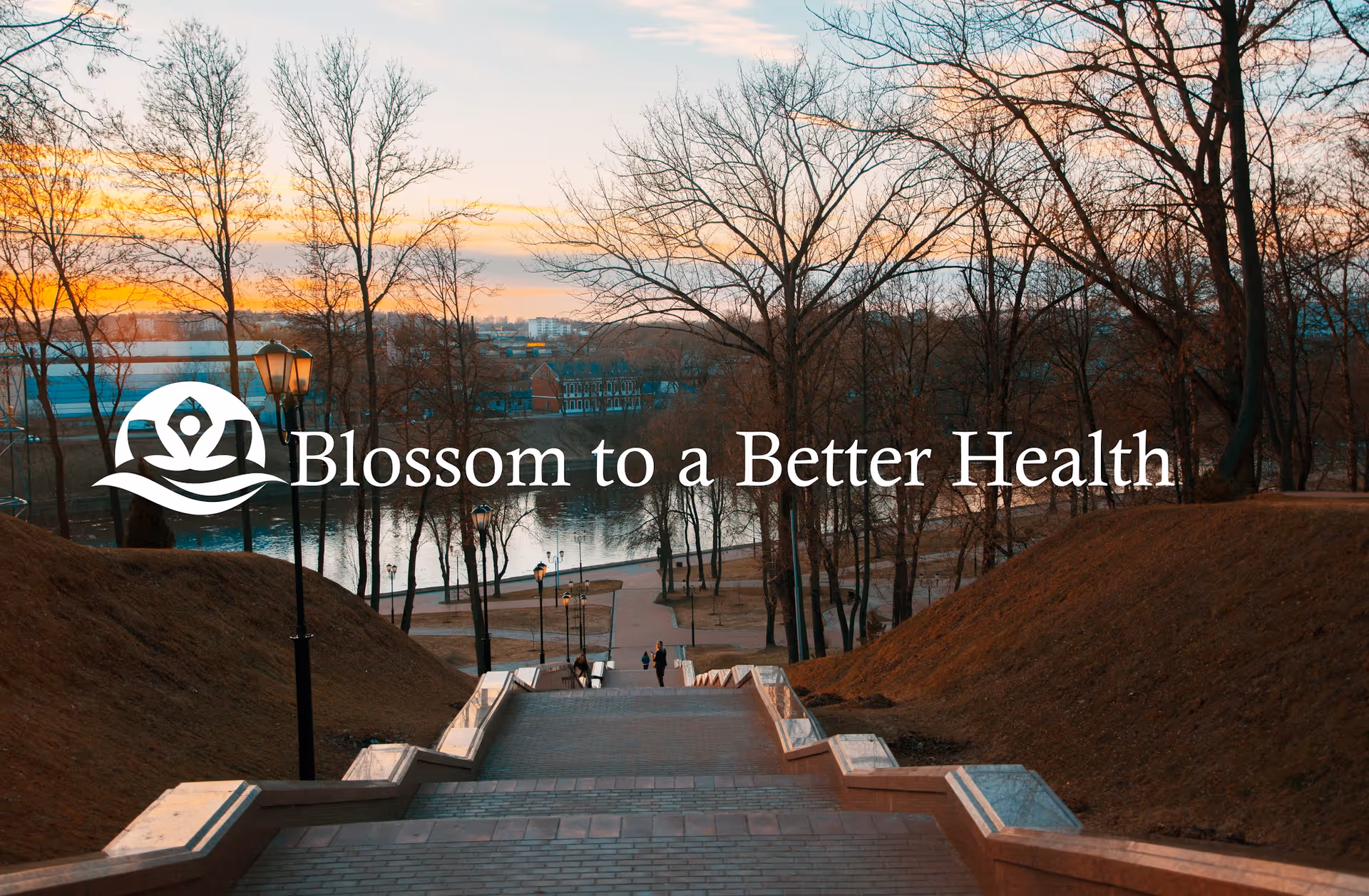 Sunlit park staircase with leafless trees, overlaid by Blossom to a Better Health logo.