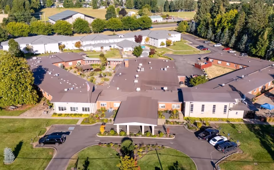 Aerial view of Providence Benedictine Nursing Center's multi-wing building with surrounding parking and greenery.