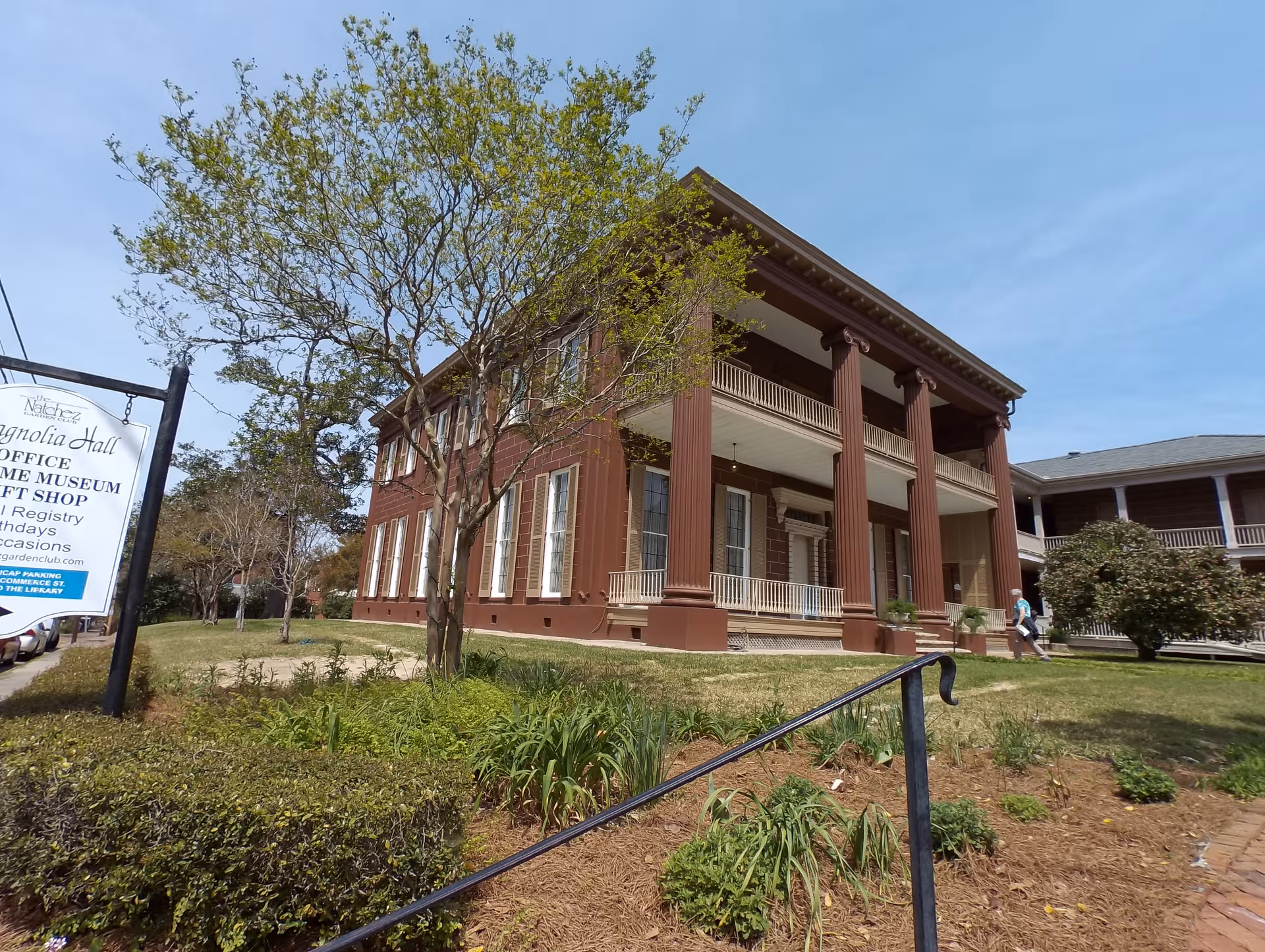 Brick, columned two-story building with a Magnolia Hall sign and landscaped front yard.