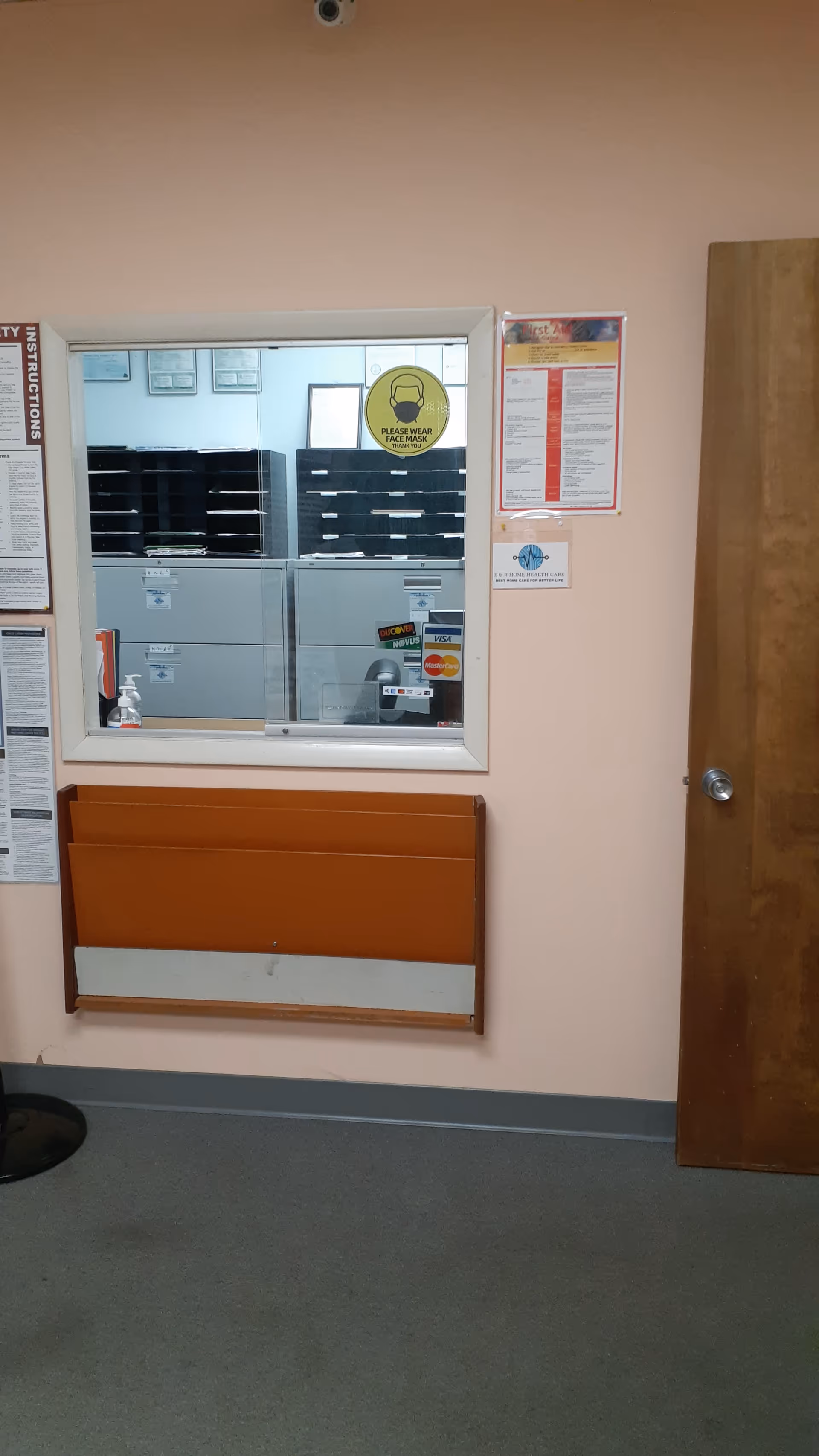 Interior view of a front desk window, mail slots, doorway, and wall signage.