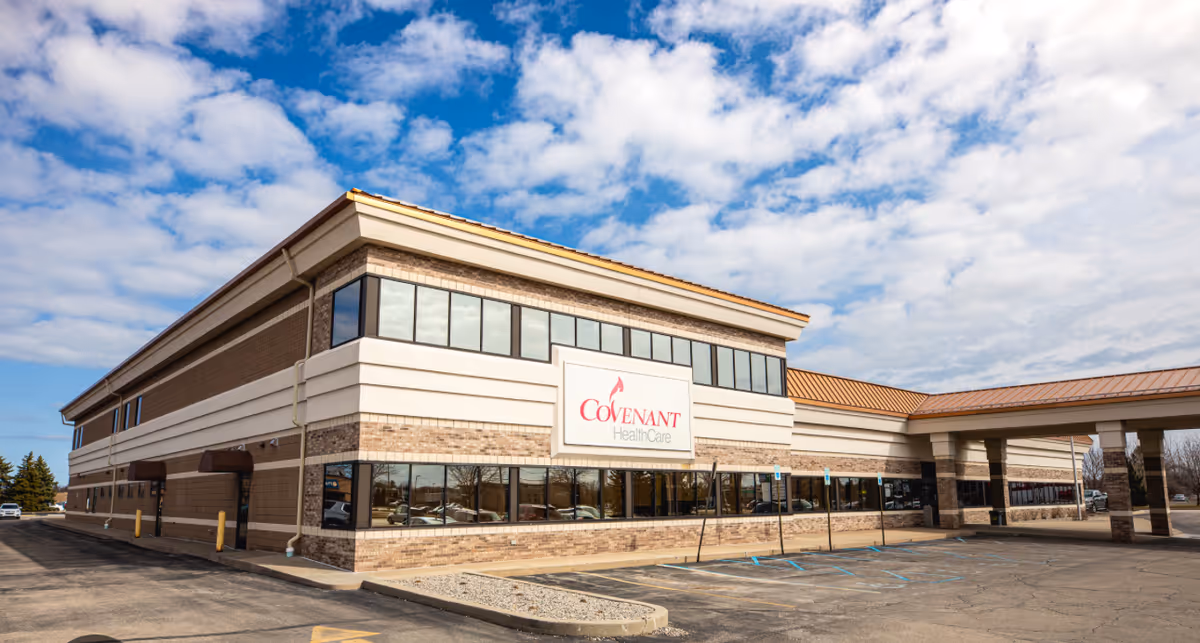 Exterior view of Covenant HealthCare building with parking lot and blue sky.