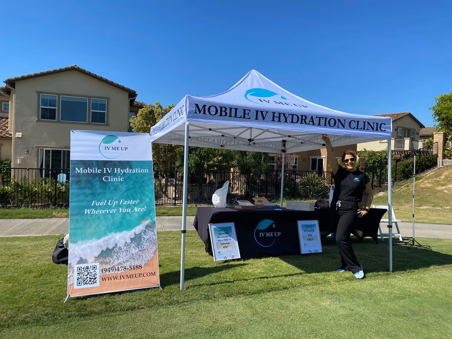 Outdoor mobile IV hydration clinic setup under a white tent with banner.