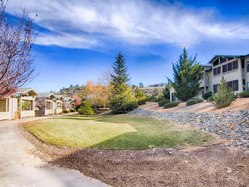 Exterior view of Evergreen Village Prescott with landscaped lawn and trees