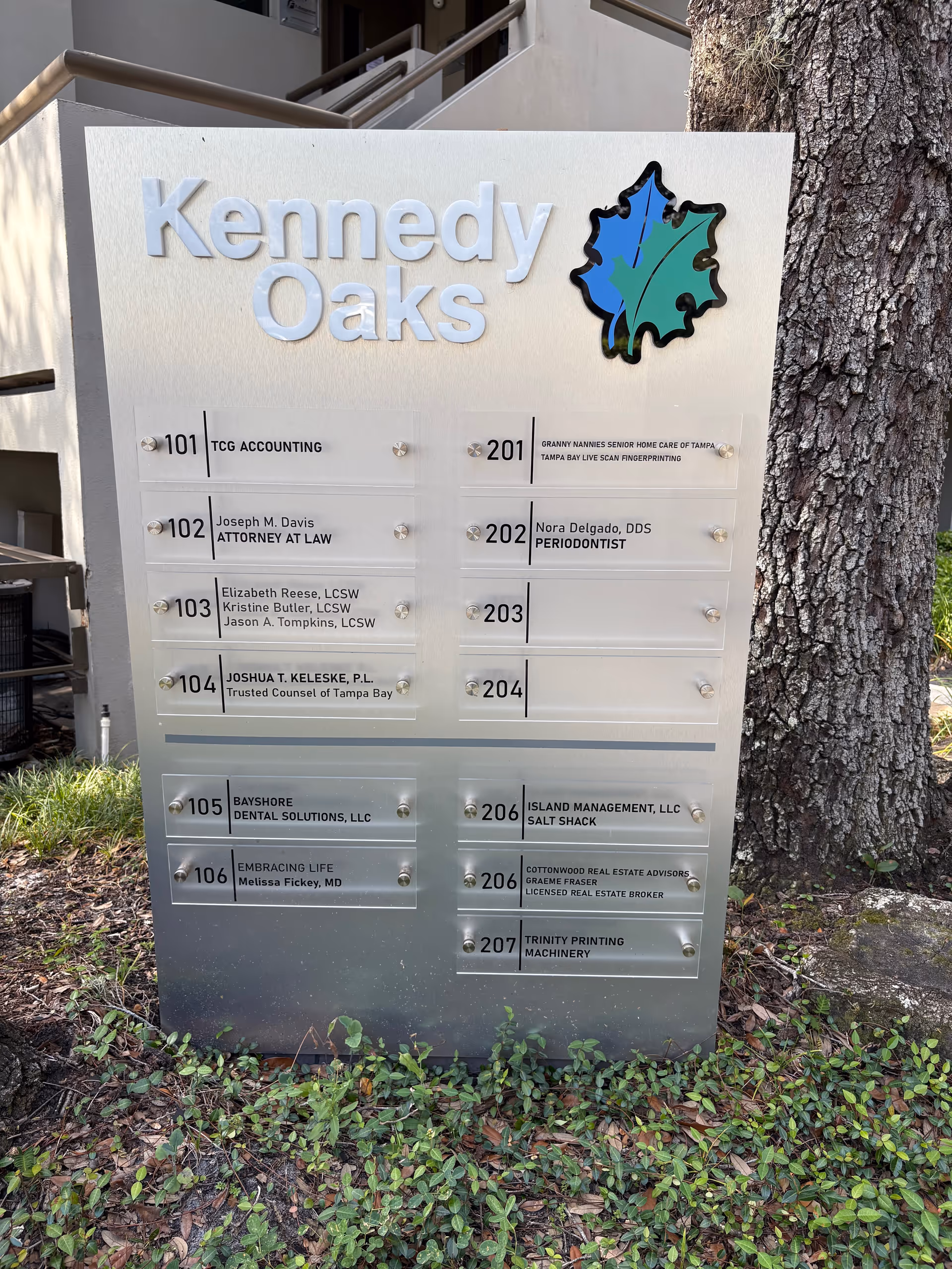 Exterior sign for Kennedy Oaks with directory plaques listing offices and suites