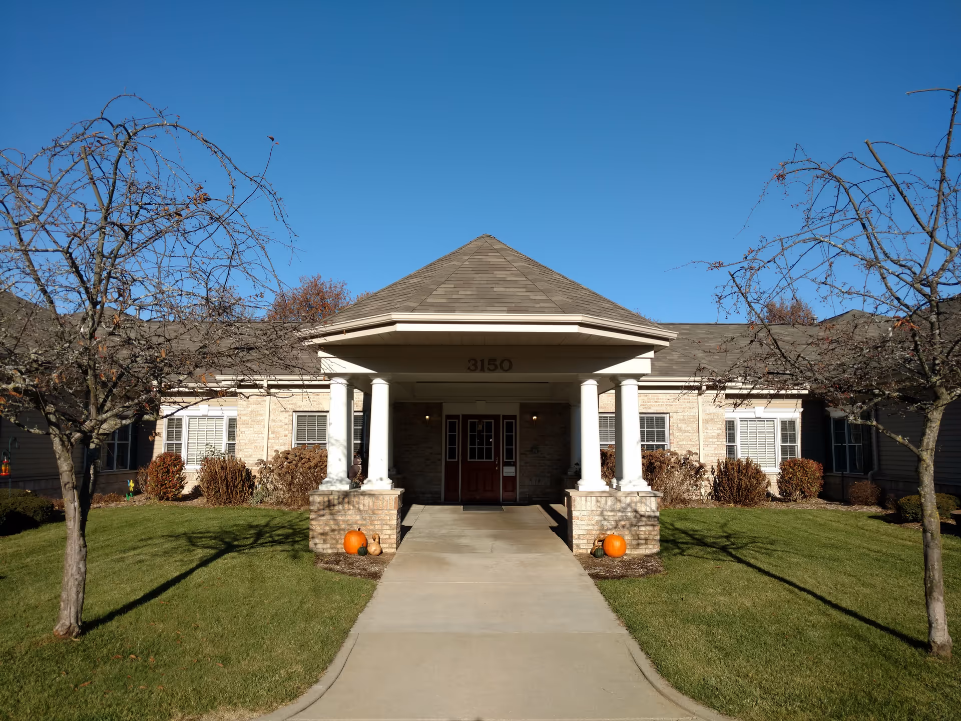 Front view of Brookdale Portage Memory Care exterior with pumpkin decorations at entrance.