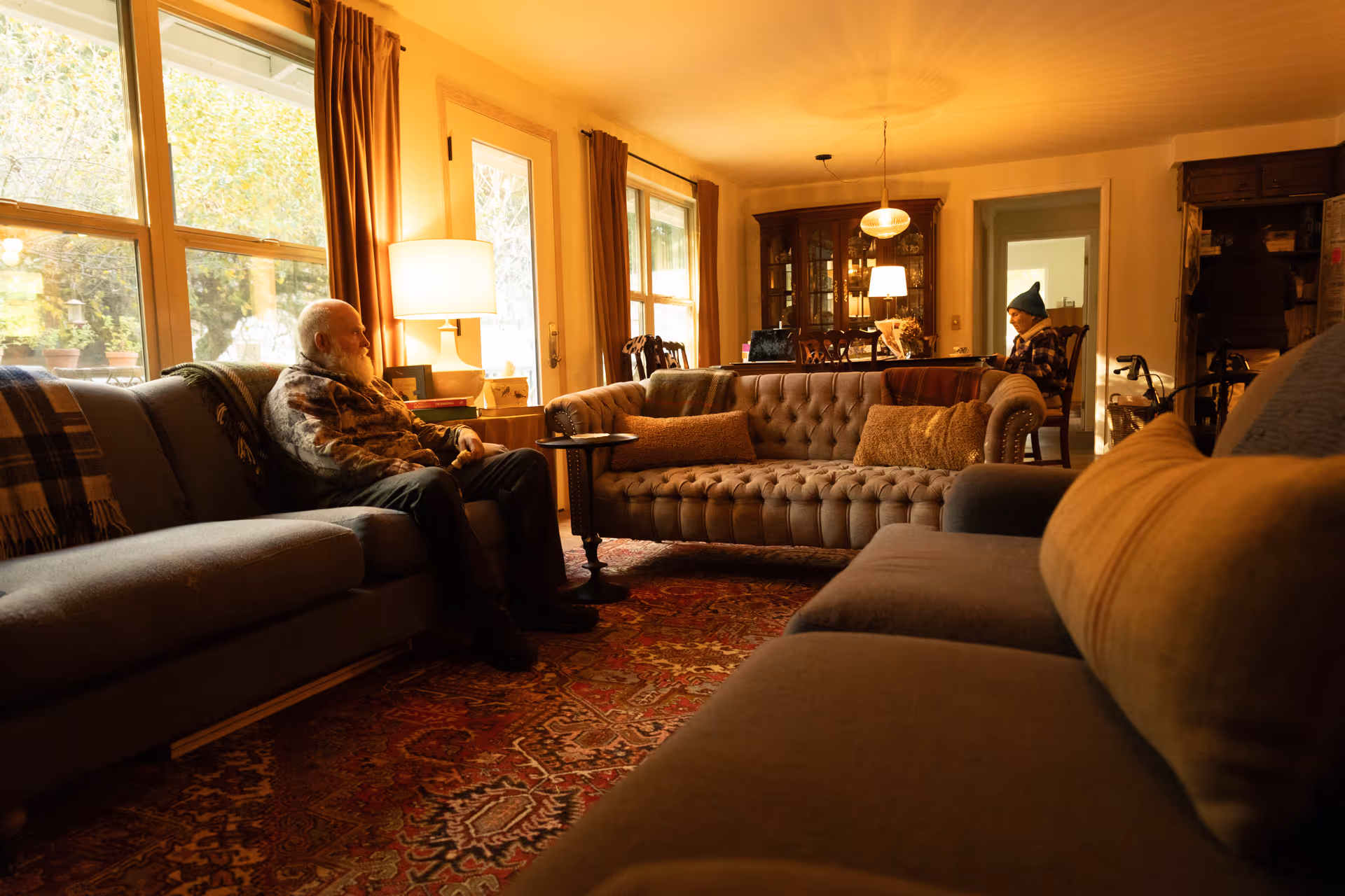 Cozy living room with elderly residents seated on sofas in Johnson Point House Adult Family Home.