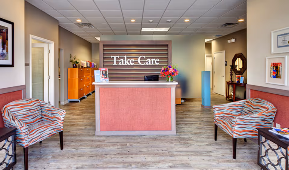 Reception area of Take Care Home Health with a front desk and waiting chairs.