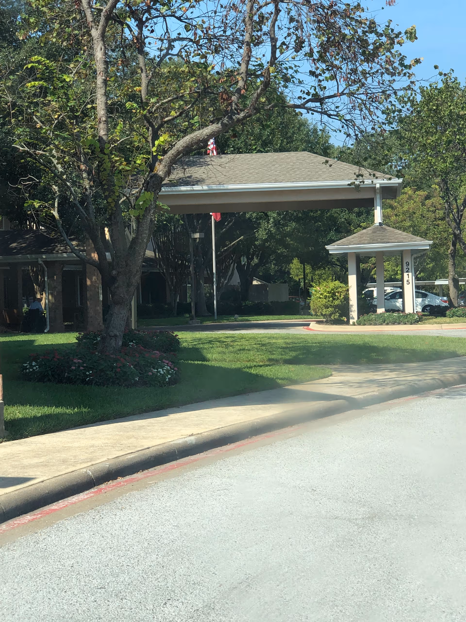 Exterior view of a senior living facility entrance with a covered drop-off area.