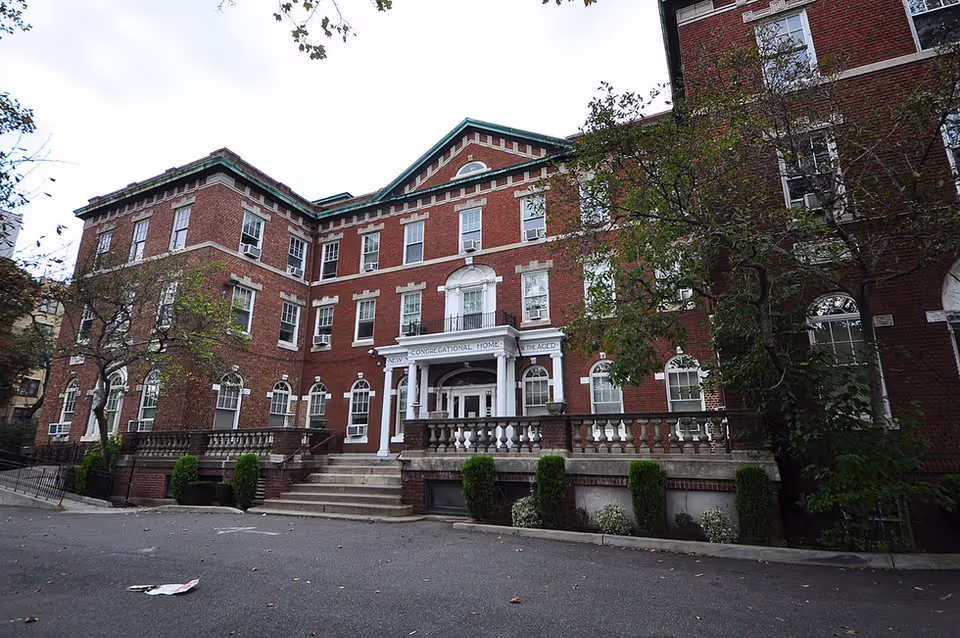 Exterior of Association Residence Nursing Home, a red brick building with white entrance and steps.