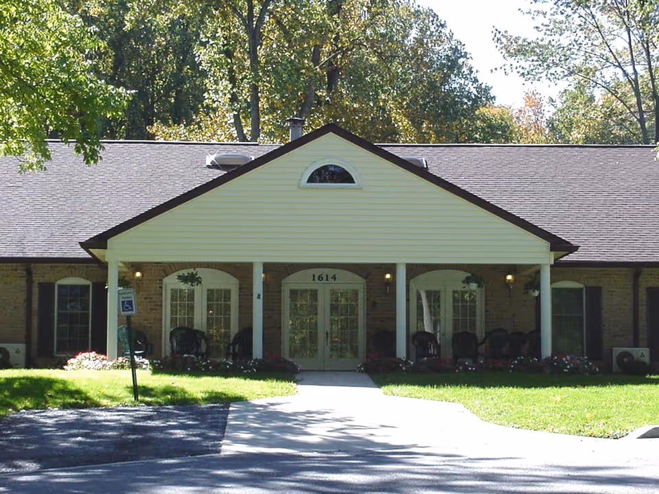Front view of a single-story assisted living building with a welcoming porch and landscaping.