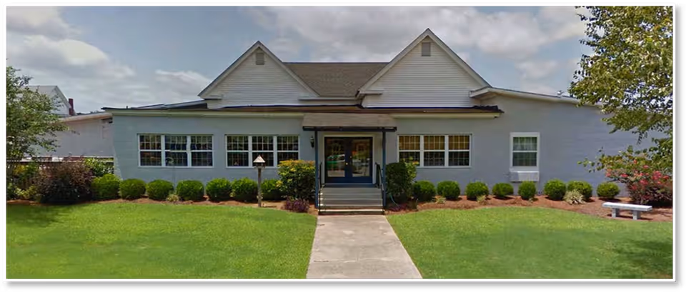 Front view of NorthSpring Senior Living: single-story facility with entrance and trimmed lawn.