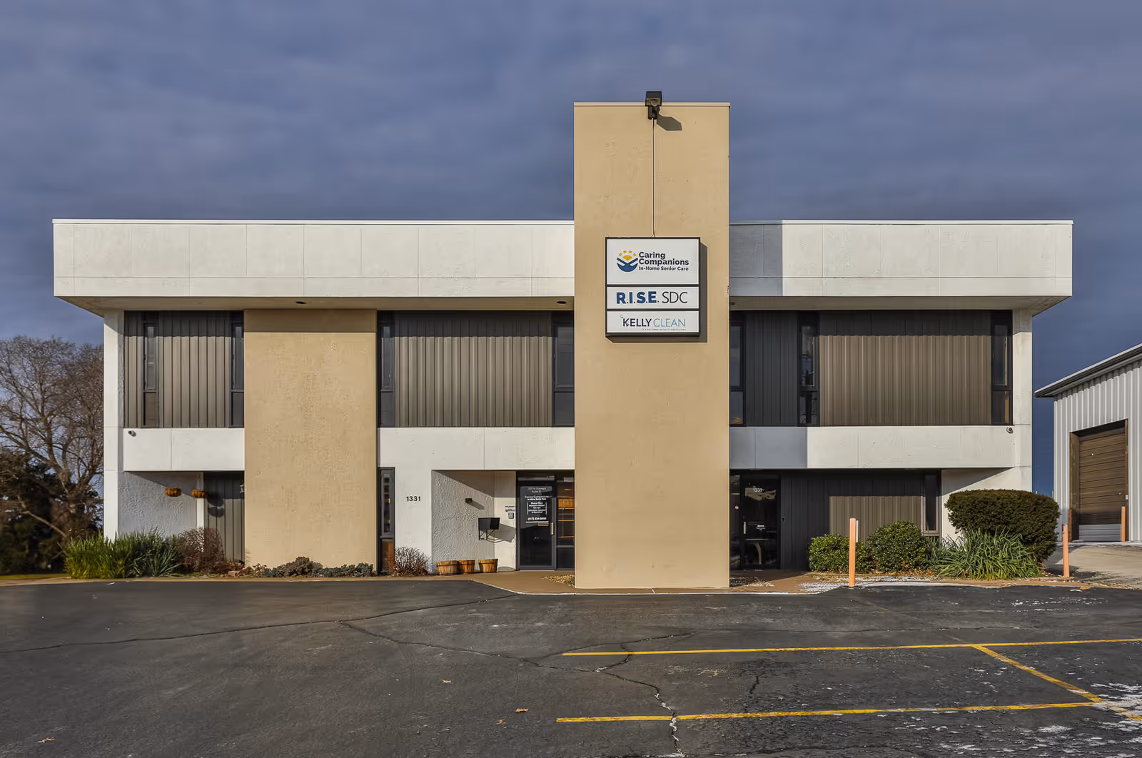 Front exterior of a two-story building with a central tower and signage.