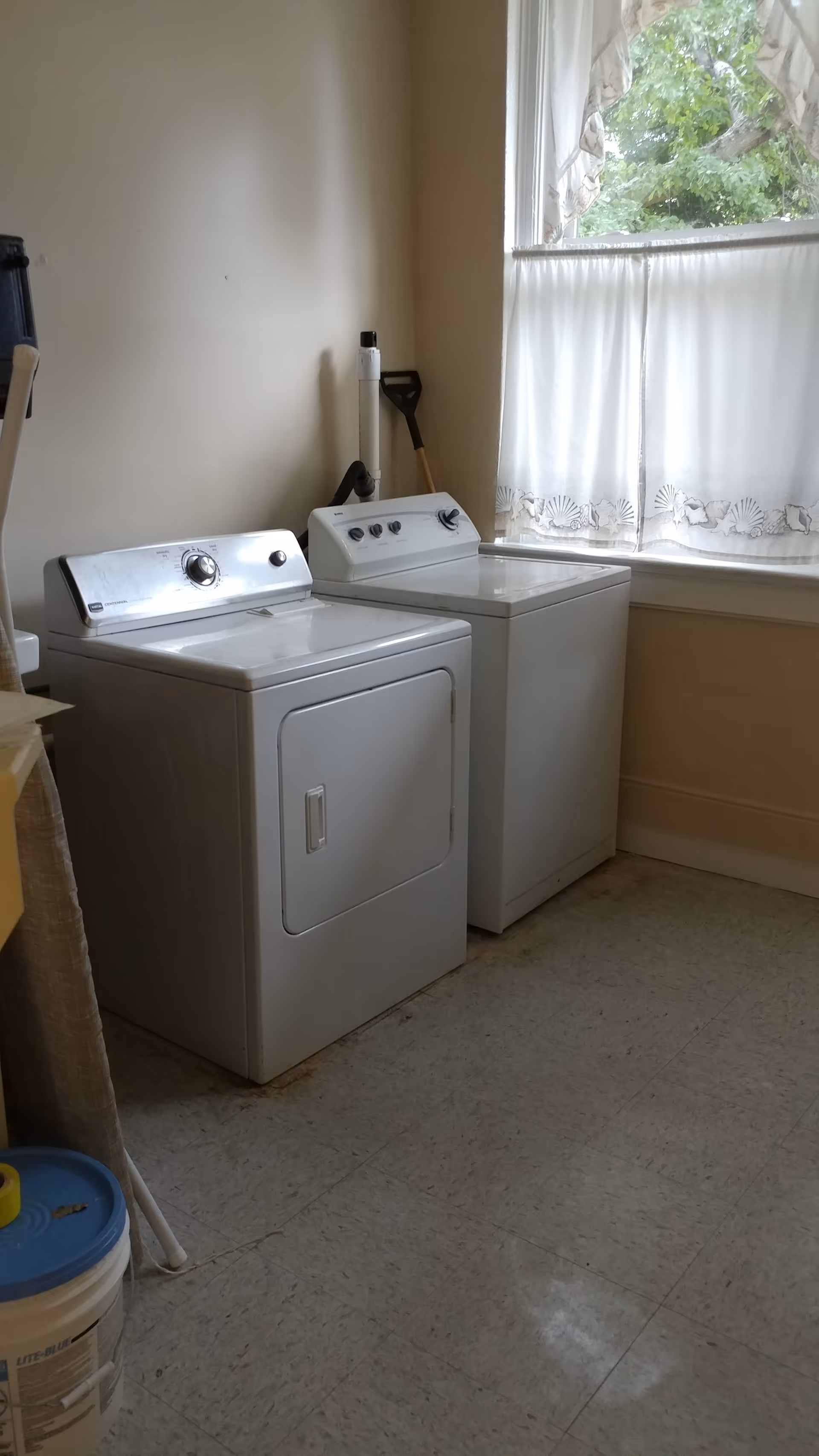 Laundry room with a washer and dryer beside a window.
