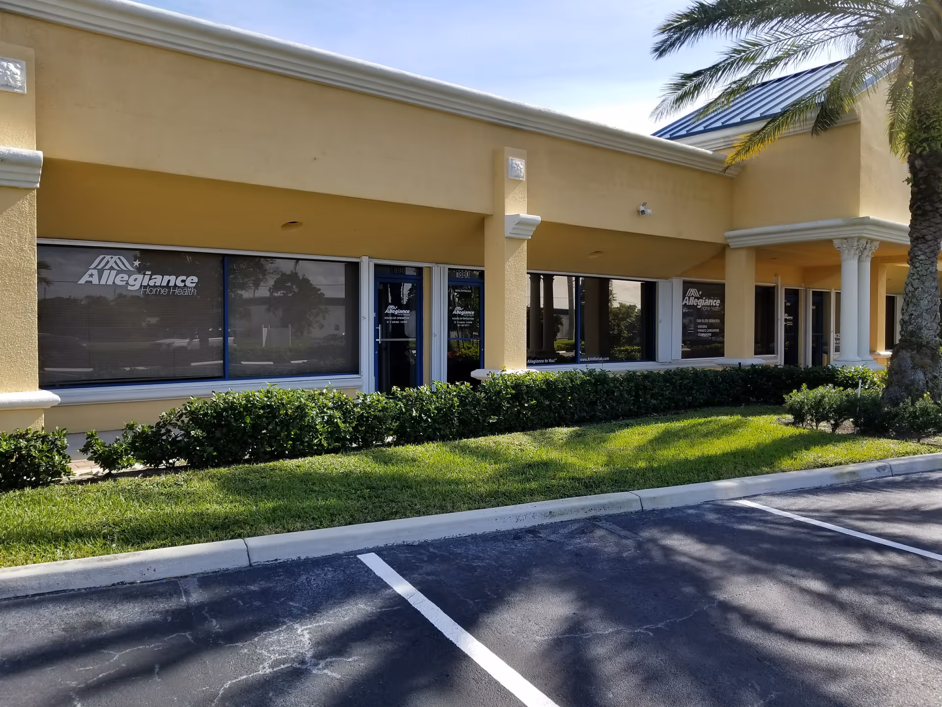 Exterior view of Allegiance Home Health & Rehab building with windows, shrubs, and a palm.