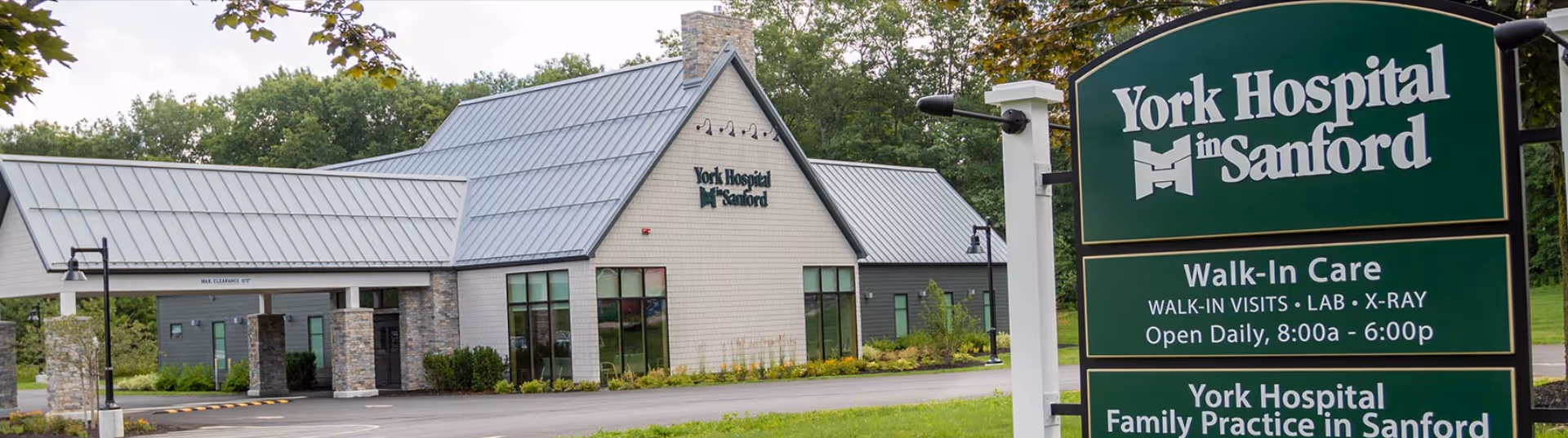 Exterior view of York Hospital in Sanford with a prominent green sign in foreground.