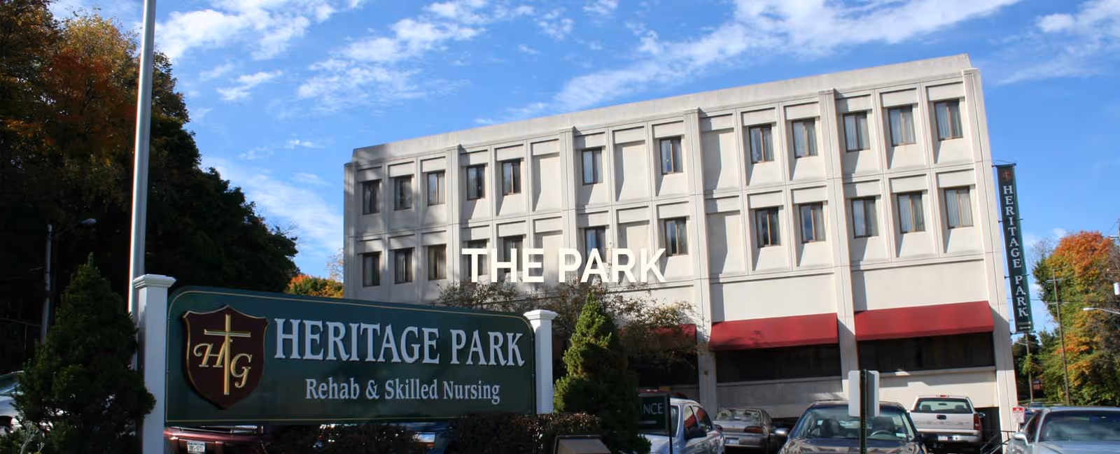 Exterior view of Heritage Park Rehab and Skilled Nursing building with parked cars.