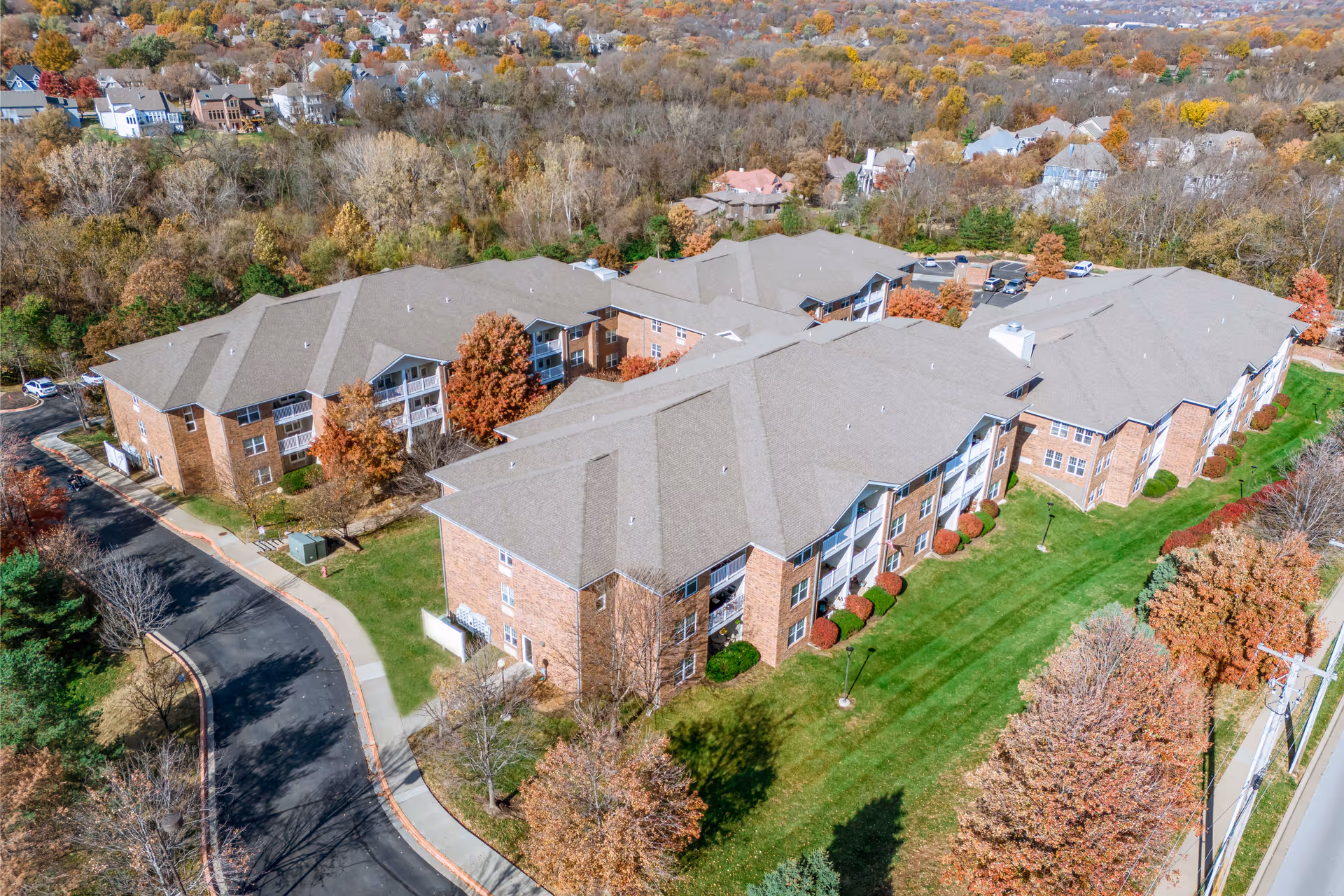 Aerial view of Rosewood Place senior living campus with brick buildings and autumn trees.