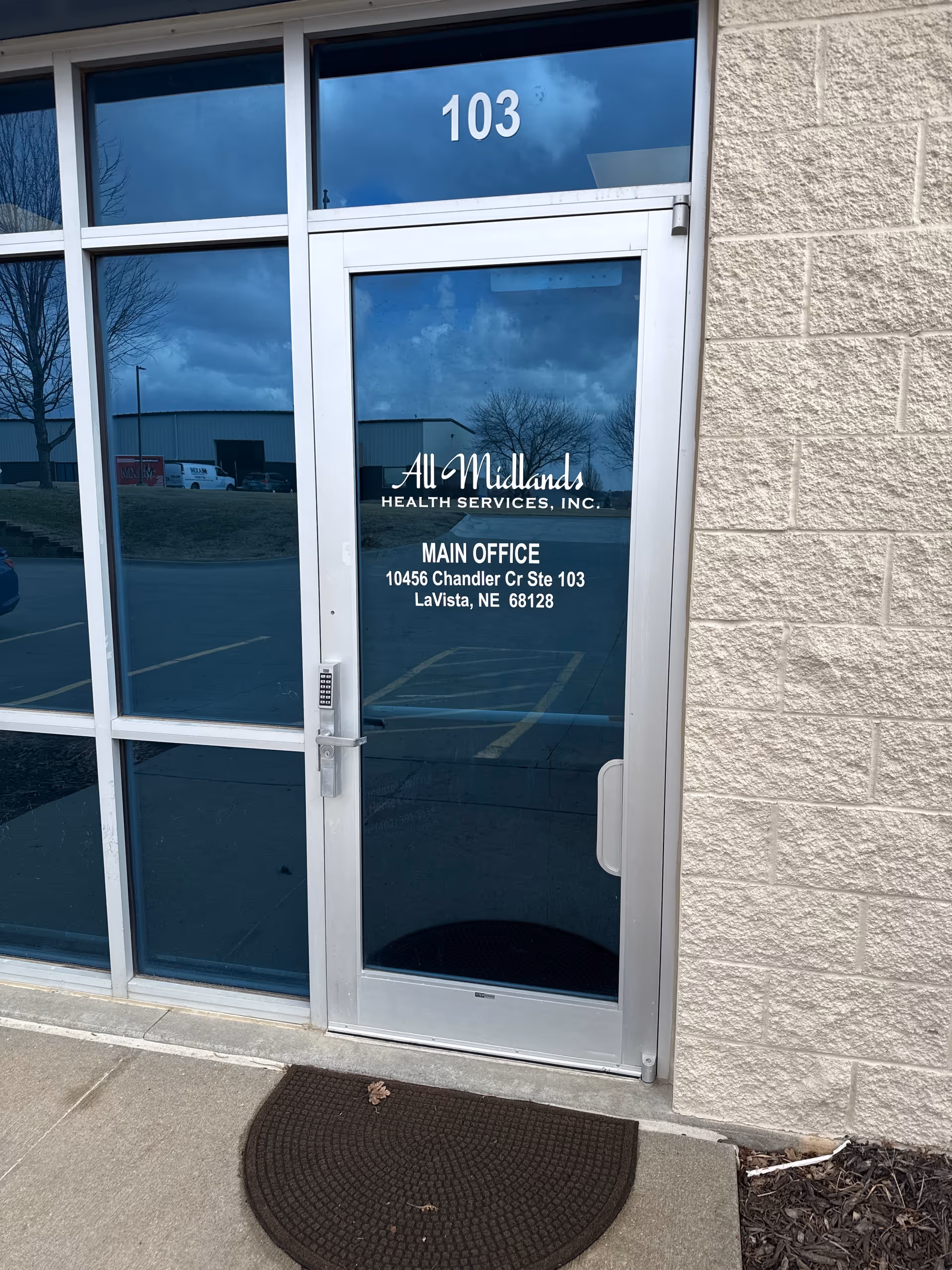 Glass door with All Midlands Health Services signage and Main Office address on the exterior.
