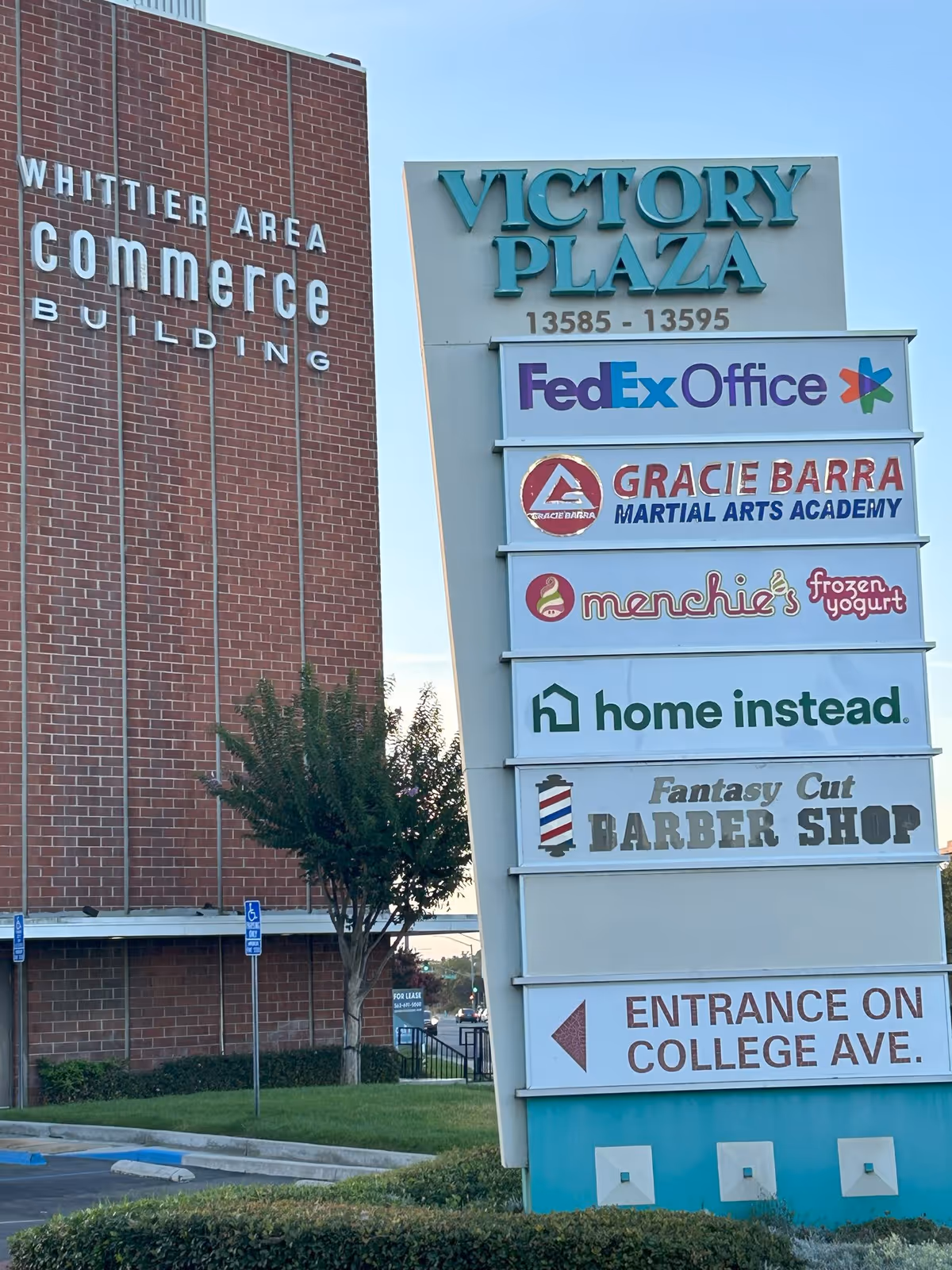 Outdoor storefront signage for Victory Plaza with multiple tenants, including Home Instead.