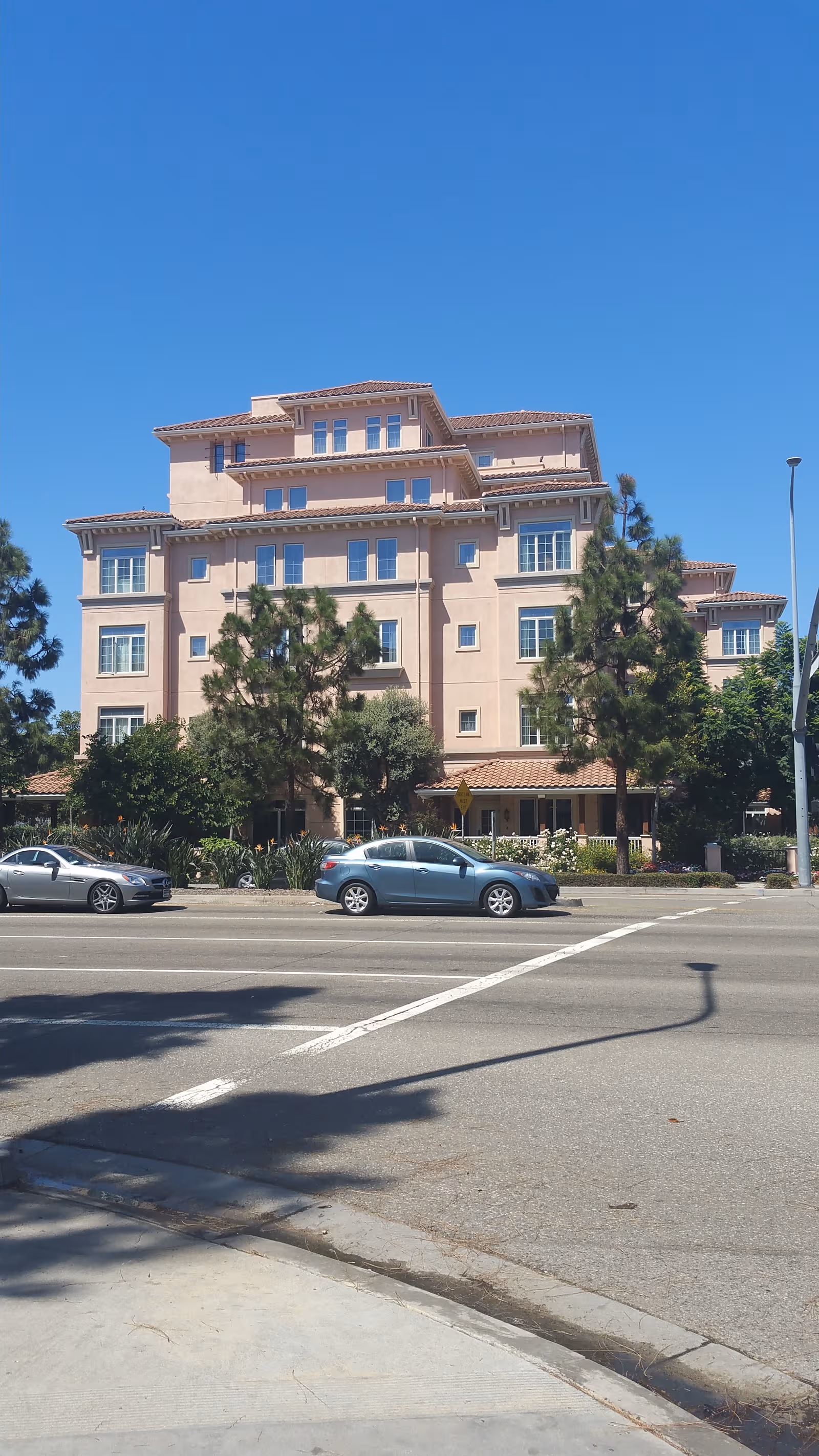 Exterior view of Ivy Park at Playa Vista, a multi-story beige senior living building.